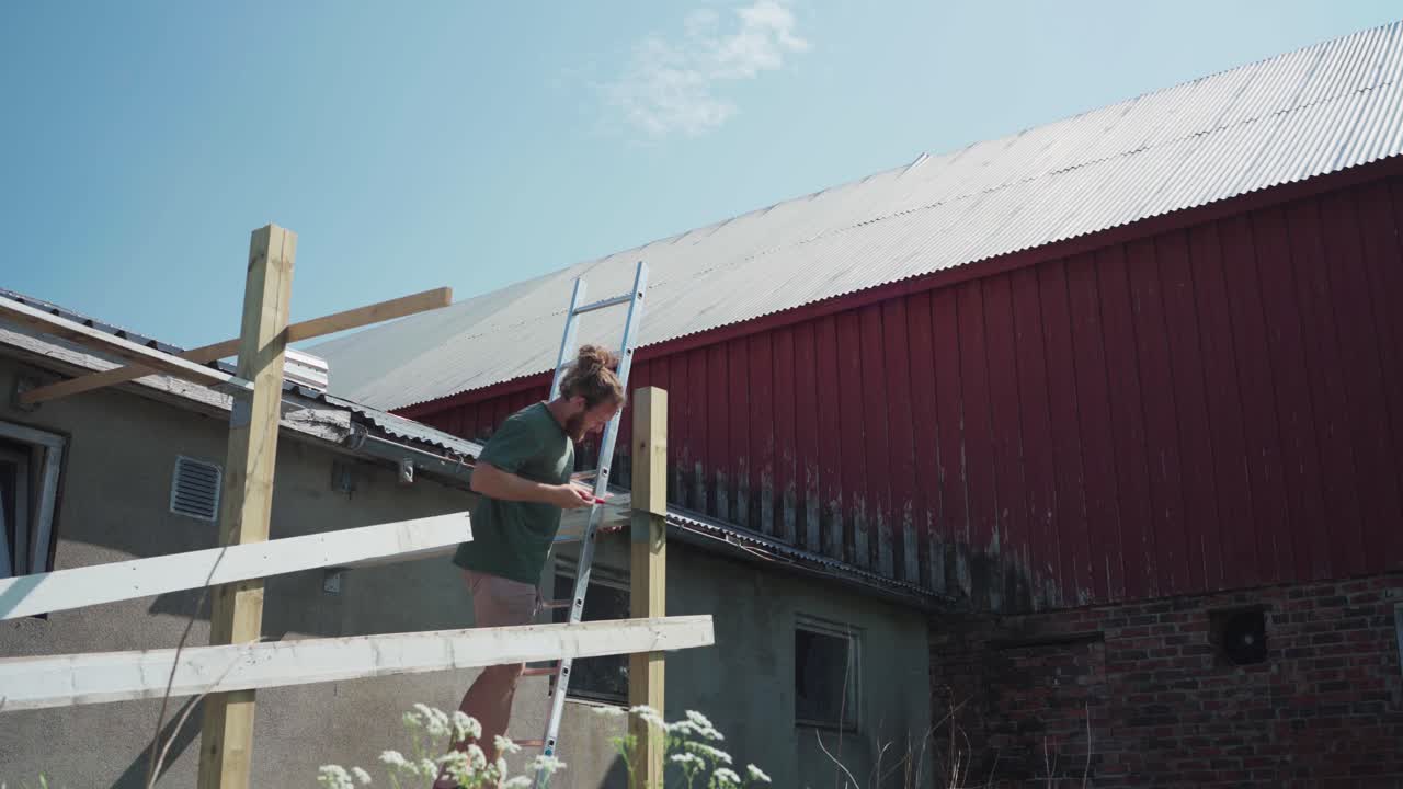 Man On Ladder Cutting The Excess Wooden Post Using Crosscut Hand Saw
