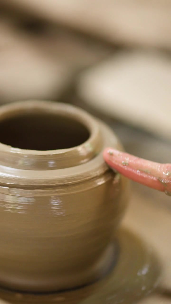 Primo piano delle mani di un vasaio che modellano un vaso di argilla bagnata a Nonthaburi, Thailandia.