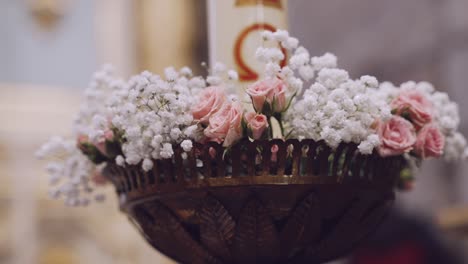 ornate flower arrangement with pink roses and baby's breath in church