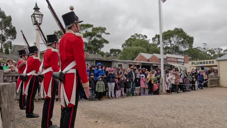 soldiers in red coats perform for a crowd