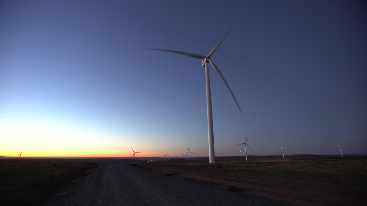 자갈길 옆 새벽의 풍력 터빈