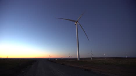 Wind-turbines-at-dawn-next-to-gravel-road