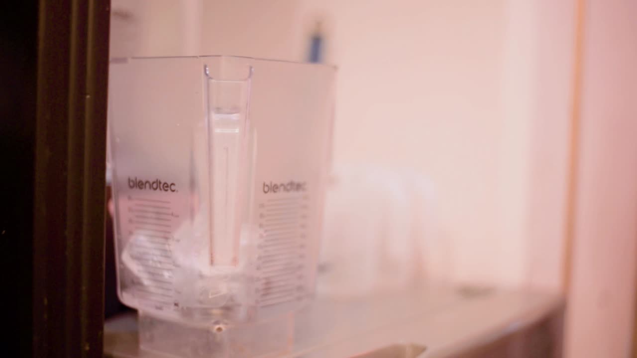 Barman barista bartender pouring ice cubes in blender at a local cafe diner restaurant in Mexico latin america