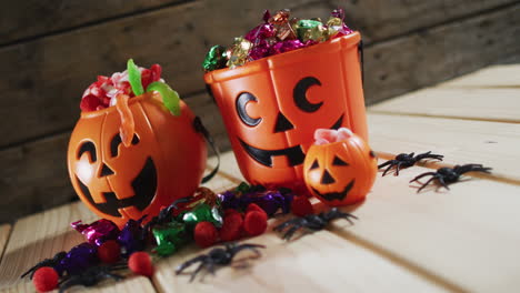 Cubos-De-Calabaza-De-Halloween-Llenos-De-Dulces-De-Halloween-Sobre-Superficie-De-Madera