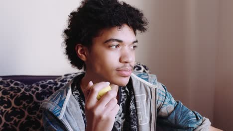 un adolescente de raza mixta come una manzana, de cerca