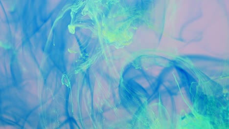 la propagación de pintura azul y verde en un espacio rosa líquido.