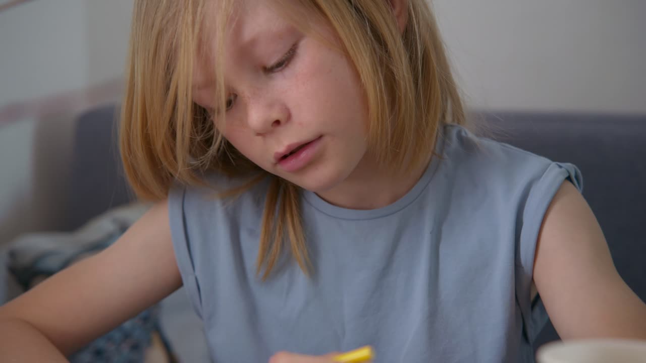 Bambina che decora uova di Pasqua con un pennarello