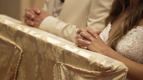 couple kneeling in prayer at an ornate altar during a religious wedding ceremony