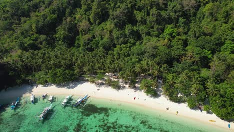 4K-drone-video-of-people-enjoying-Papaya-Beach,-a-tropical-white-sand-beach-in-Palawan,-Philippines