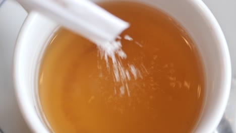 a cup of tea with sugar and a spoon