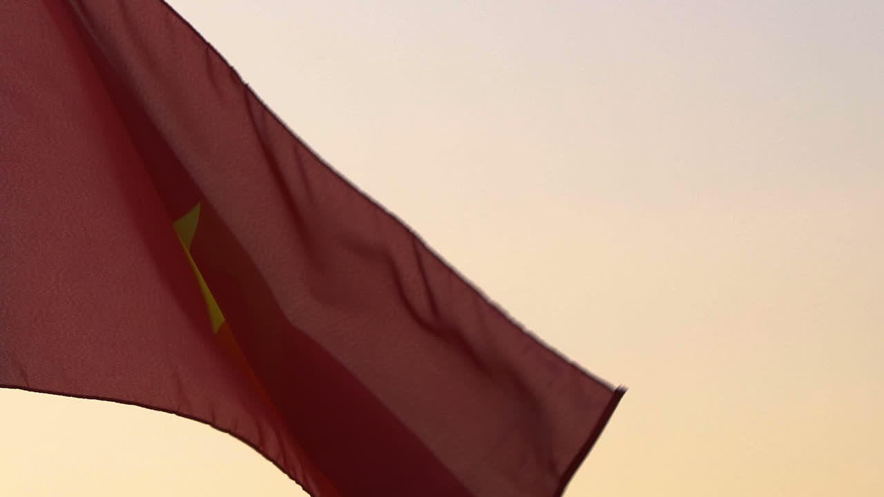 la bandera de vietnam ondeando sobre el cielo al atardecer.