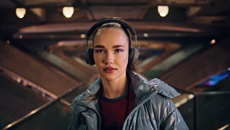 portrait beautiful girl headphones at evening city. trendy woman listening music