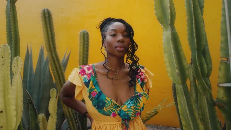 woman in a yellow floral dress amidst cacti plants