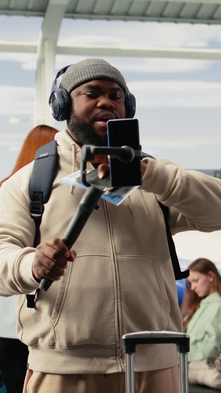 Video verticale: vlogger afroamericano che riprende momenti di viaggio con lo smartphone