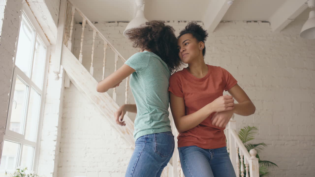 Two happy girls dancing at home