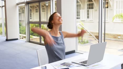 Female-business-executive-using-mobile-phone-at-desk