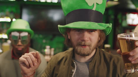 bearded man in green hat dancing in pub