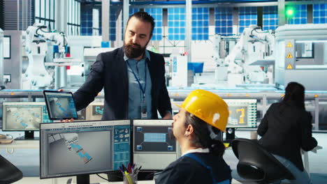 manager instructs solar panels plant employee on how to use cad software