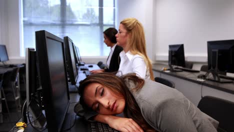 una mujer cansada durmiendo en un teclado.