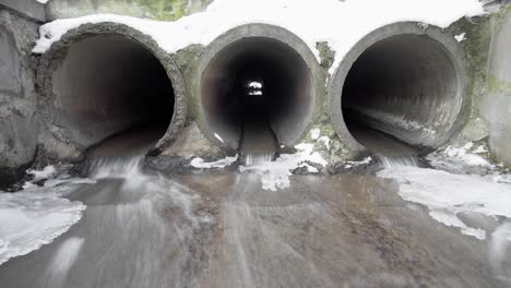 tre tubi di drenaggio in cemento che rimuovono la neve e il ghiaccio fusi, timelapse.