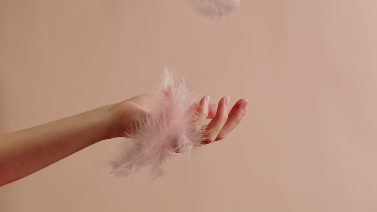 Woman's hand with pink feathers