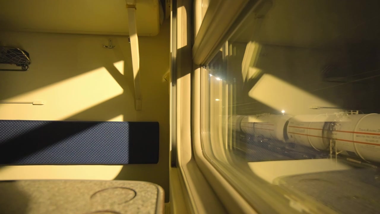 Vista notturna dal finestrino del treno di vagoni cisterna industriali.