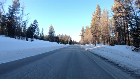 Crossing-Nes-mountain-road-Rukkedalvegen-between-Nesbyen-and-Langedrag-in-Norway---Highland-road-with-snow-during-morning-sunrise-seen-from-car-front