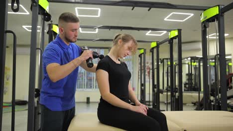 certified therapist provides necessary support to client undergoing neck therapy in trendy modern certified therapist provides necessary support to client undergoing neck therapy in trendy modern gym muscle massager