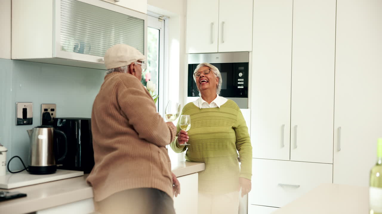 An older couple enjoying a glass of wine in their kitchen