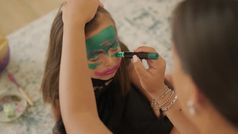 little girl getting face painted for halloween