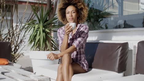 young woman drinking coffe outdoors