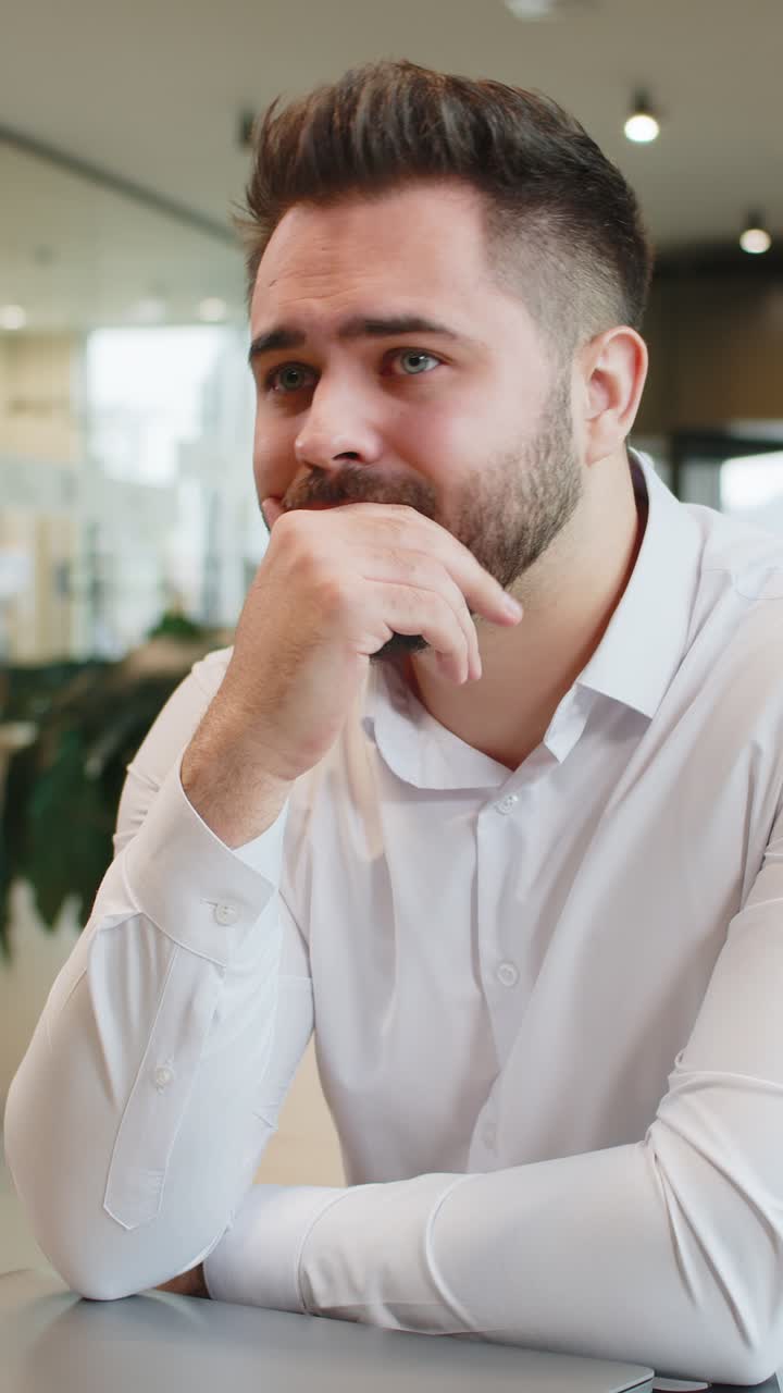 Sad businessman using laptop loses becoming shocked sudden lottery results in modern hotel lobby