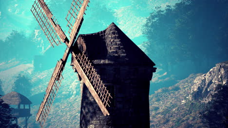 a wooden windmill on a hill with fog in the background