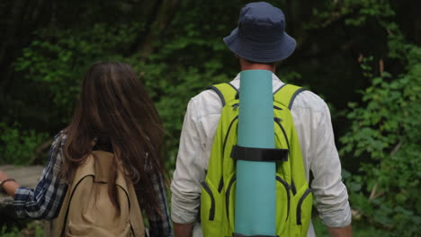 pareja de senderismo en el bosque con una alfombra de yoga