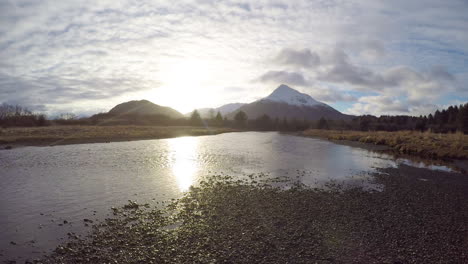 阿拉斯加科迪亞克島 (kodiak island) 的山脈和三文魚河 (salmon river) 上的日落和移動的雲