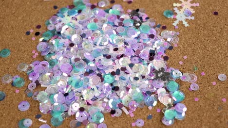 lentejuelas de colores fríos que brillan sobre una alfombra de corcho