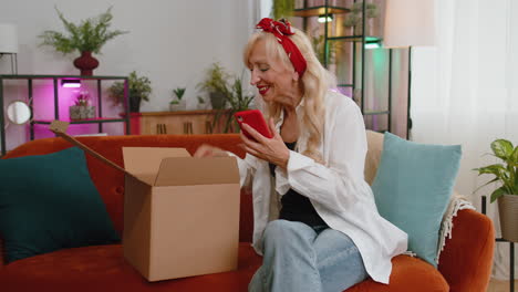 happy senior woman shopper unpacking cardboard box delivery parcel online shopping purchase at home