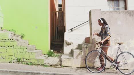 mixed race man walking with a bike