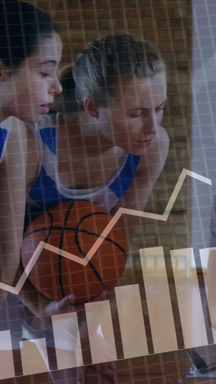 Video verticale: Duo di adolescenti cestisti appoggiati in palestra, un feed fuori campo invia grafici AR per l'allenamento.