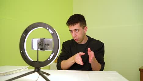 male coach influencer speaking in front of cellphone camera with ring light during online course