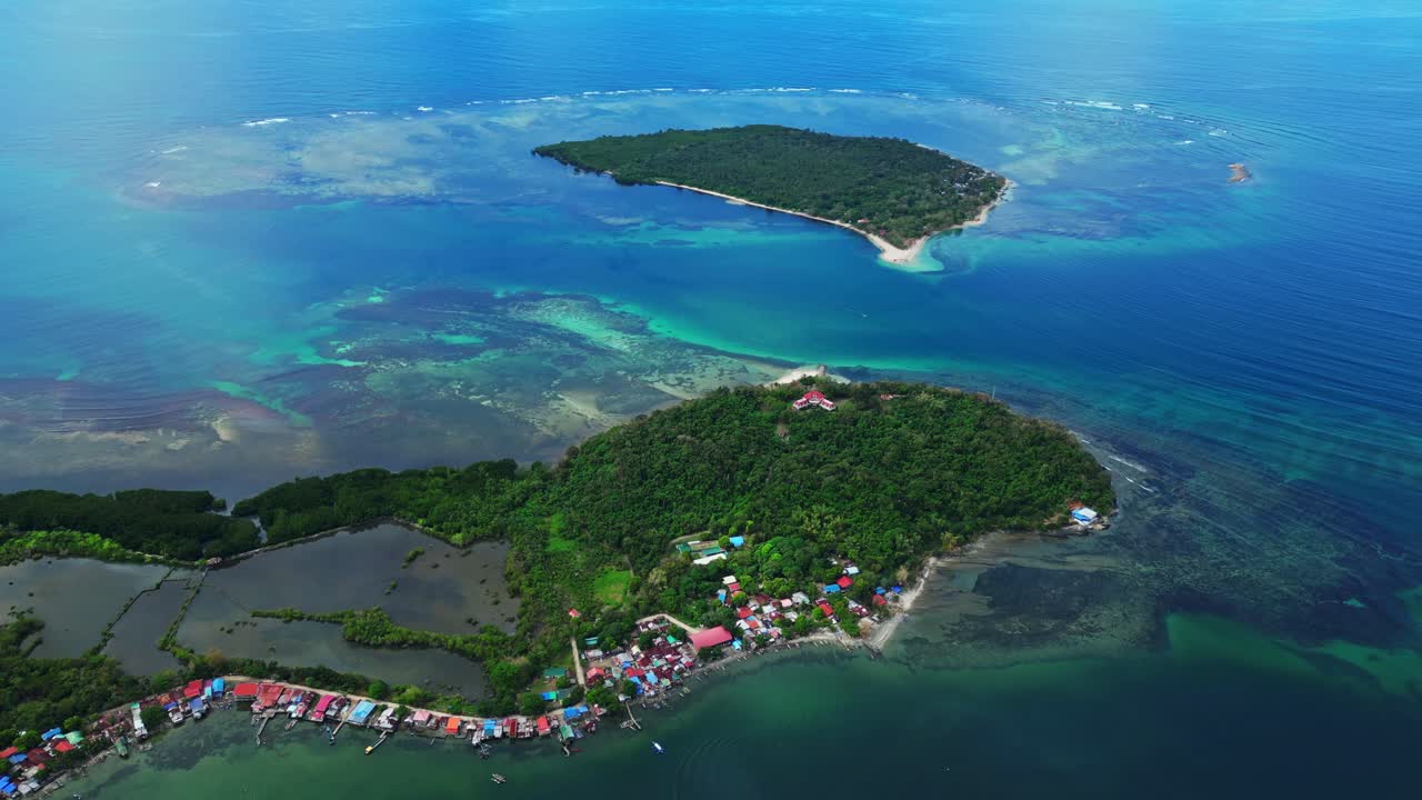 ภาพมุมกว้างทางอากาศแบบพาโนรามาที่แสดงให้เห็นเกาะ Magalawa ที่ล้อมรอบด้วยน้ำทะเลสีเทอร์ควอยซ์ที่ไม่มีที่สิ้นสุดและพื้นที่สีเขียวที่สดใส