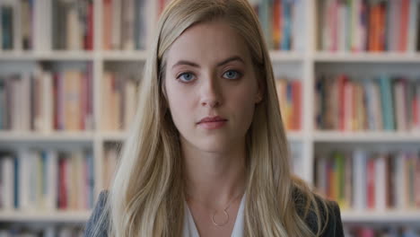 portrait beautiful young blonde business woman looking serious at camera pensive independent female in bookshelf background