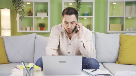 Hombre-Ocupado-Trabajando-En-Casa-Hablando-Por-Teléfono-Sobre-El-Trabajo-Mientras-Usa-Una-Computadora-Portátil.