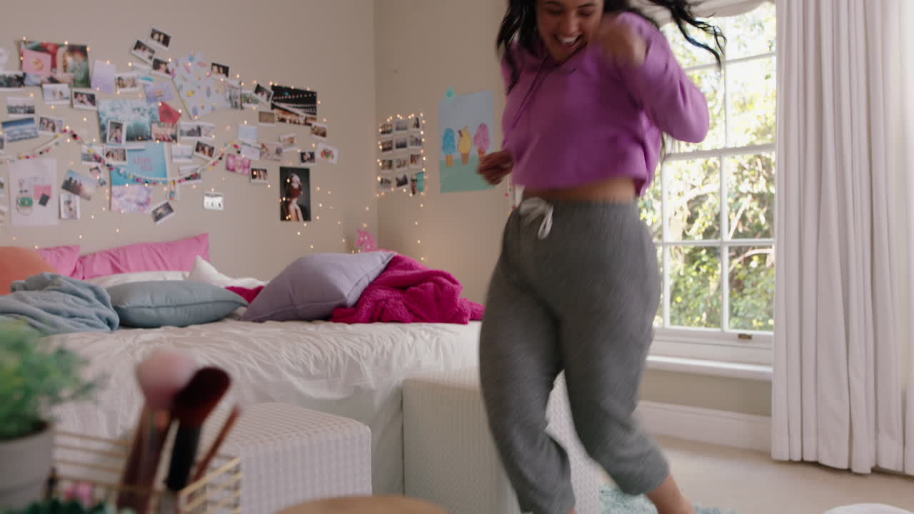 una adolescente con sobrepeso feliz bailando en el dormitorio divirtiéndose bailando celebrando el fin de semana sintiéndose positiva vistiendo pijama en casa