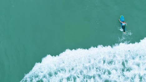 4k top down aerial shot of people learning to surf in pondicherry beach