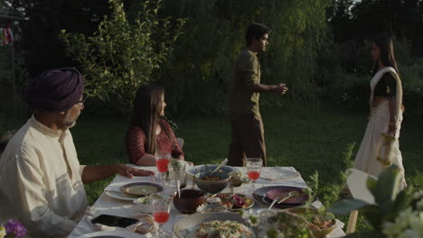 people enjoying an outdoor indian family gathering in a garden