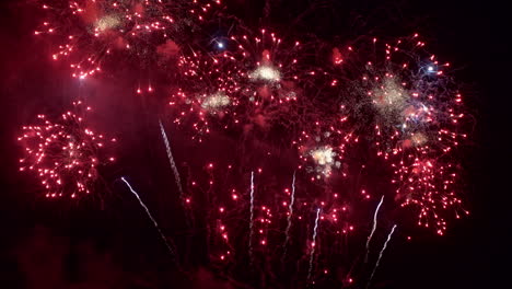 el cielo nocturno se llena de fuegos artificiales rojos