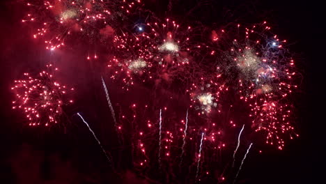 the night sky fills with red fireworks