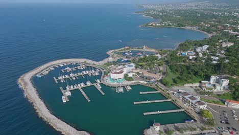 Aerial-tilt-down-shot-of-marina-port-of-Puerto-Plata-with-yacht-and-sailing-boat-in-summer