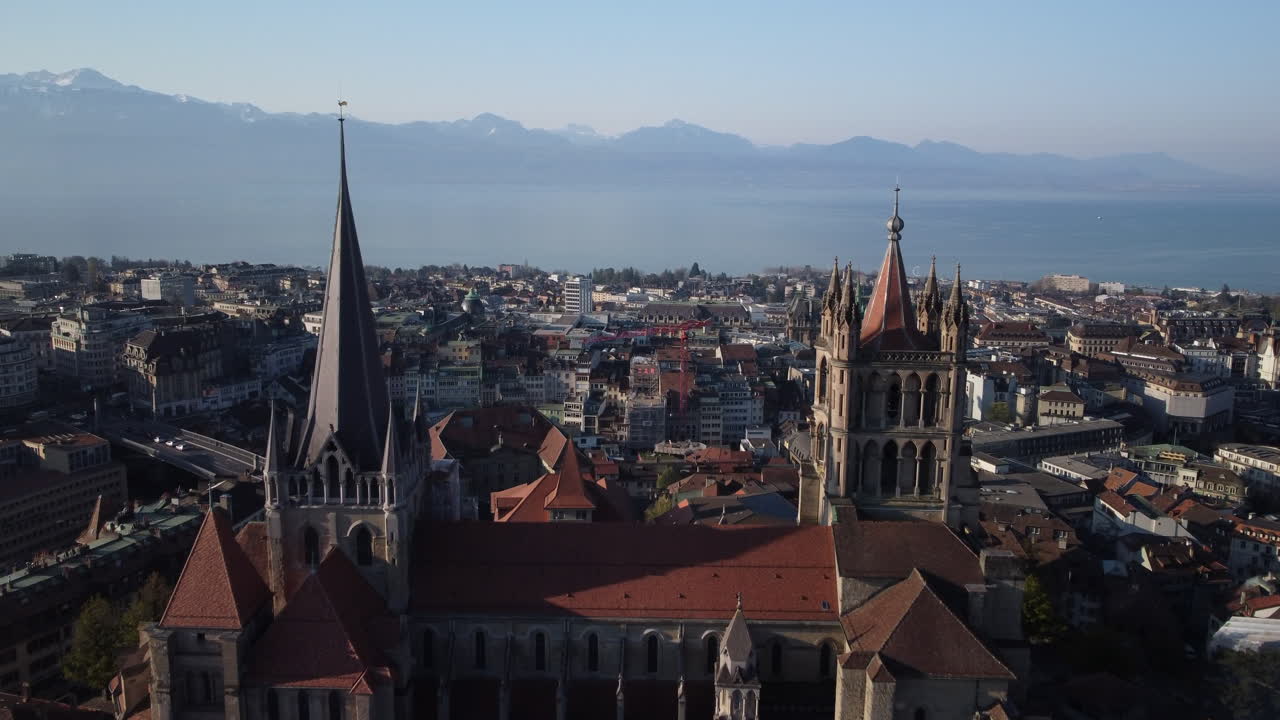 스위스 로잔에 있는 르네상스 건물의 두 개의 큰 탑 사이를 천천히 공중 비행